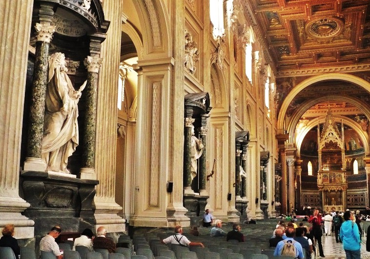 Archbasilica of St John Lateran (San Giovanni in Laterano), part of the nave with statues of the twelve apostles, in front of the baldacchino (canopy) over the altar containing the heads of Sts Peter and Paul.  The papal cathedra is in the apse beyond.